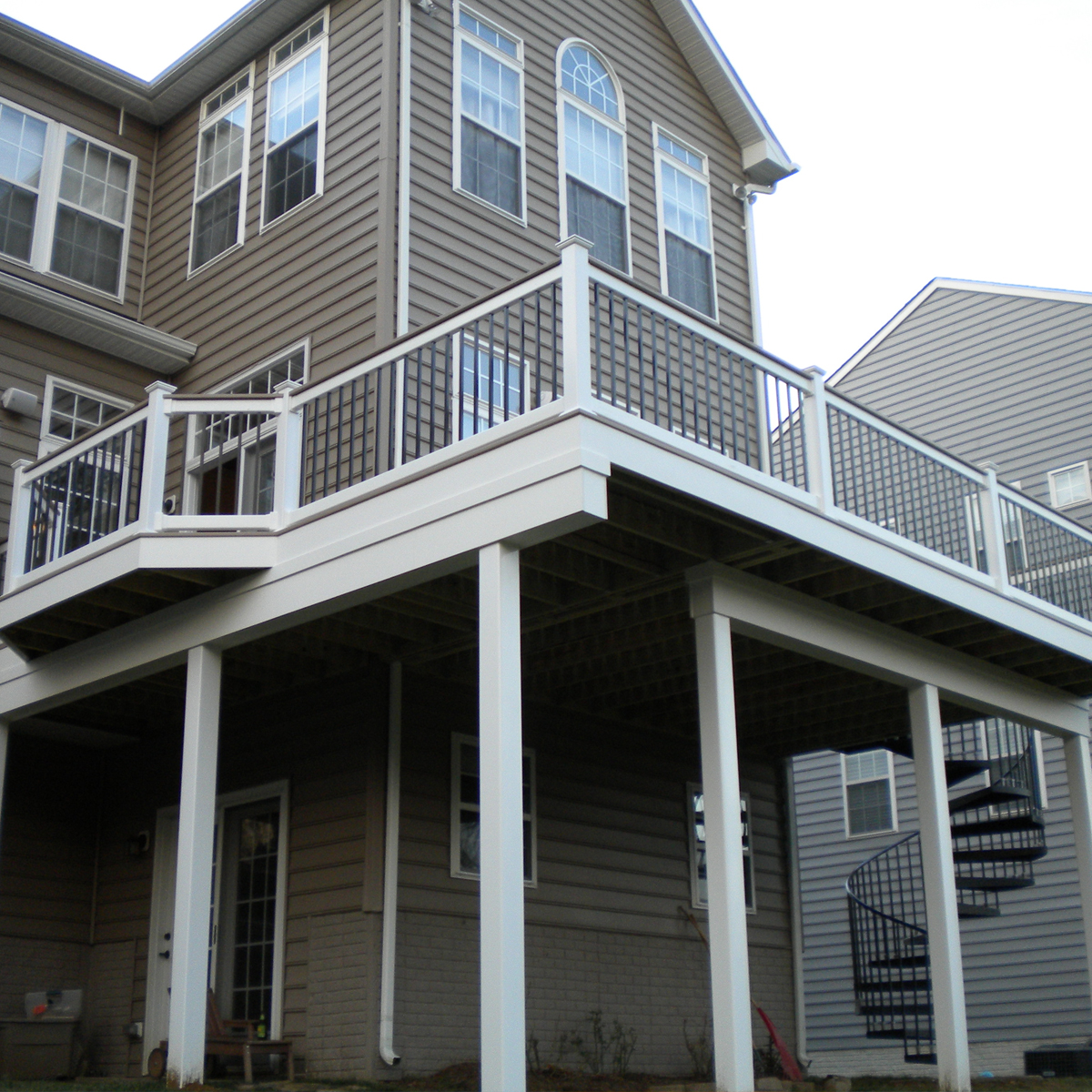 Rear deck on second story showcasing a spiral staircase to the backyard.