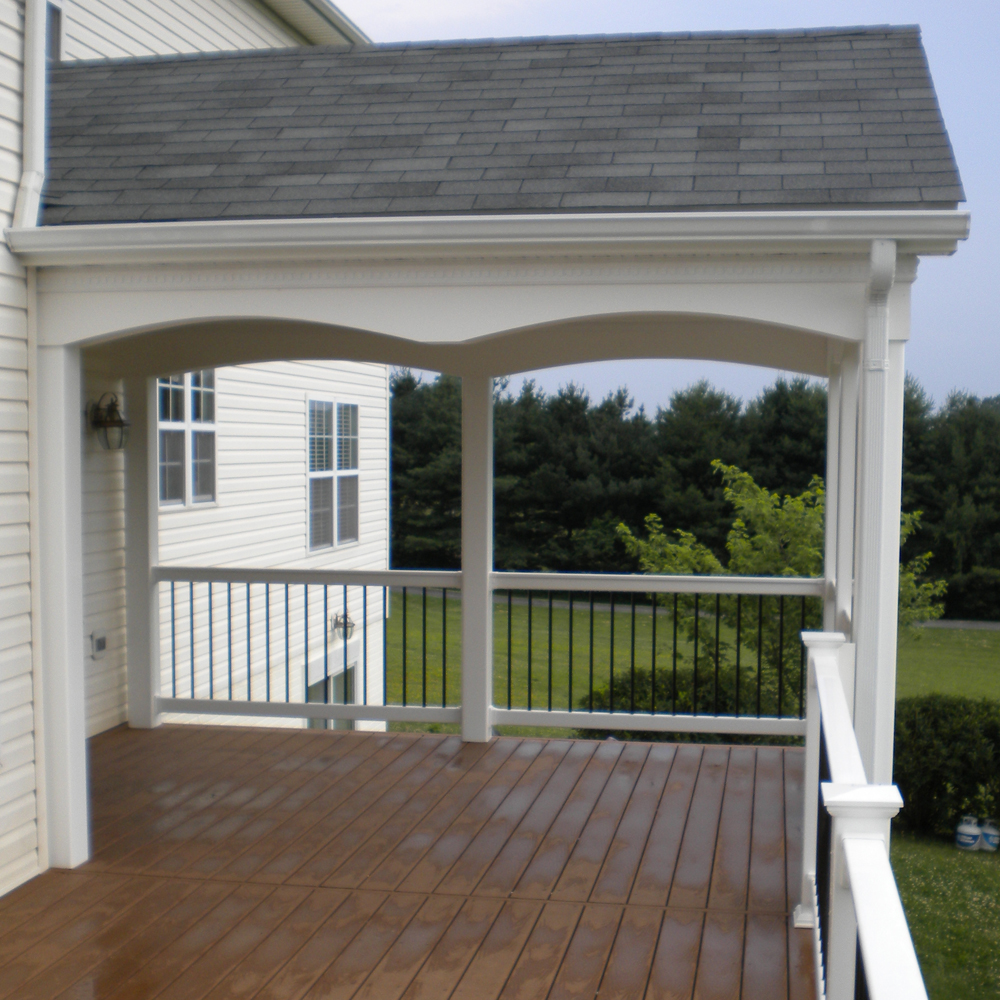 A covered deck with custom railing.